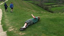 The youngsters take it in turns to roll down the hill from the top of Glastonbury Tor