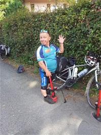 John borrows a pump from the warden to pump up his tyres outside Château d'Oex Youth Hostel