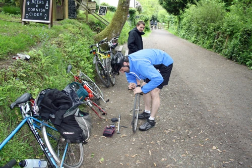 Tao tackles a puncture outside Boscarne café - so much for 'fastest'.