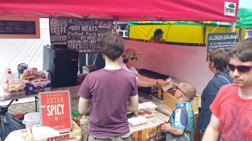 John buys something hot at Totnes food market.