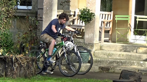 Lawrence shuttles two bikes from the shed to Bath Youth Hostel’s front