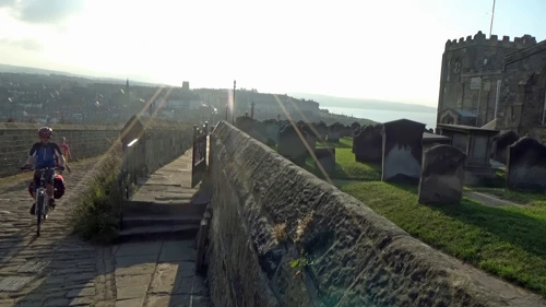George tops out on the steep Church Lane climb, Whitby—near the hostel.