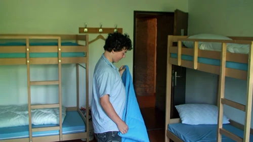 Lawrence tidies his bed as we prepare to leave Avenches Youth Hostel