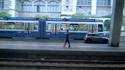 Trams pass Zurich rail station on a very wet morning
